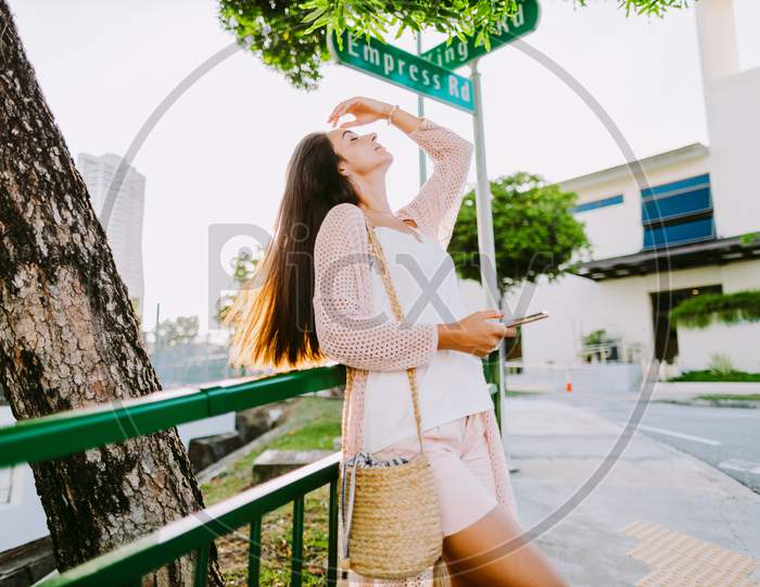 Long Hair Woman Using Phone And Chatting Standing Outdoors Near Road