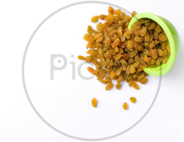 Fresh raisin in a green bowl with a white background.