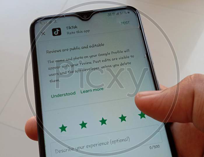 A man giving 5 star rating to the app tik tok on play store