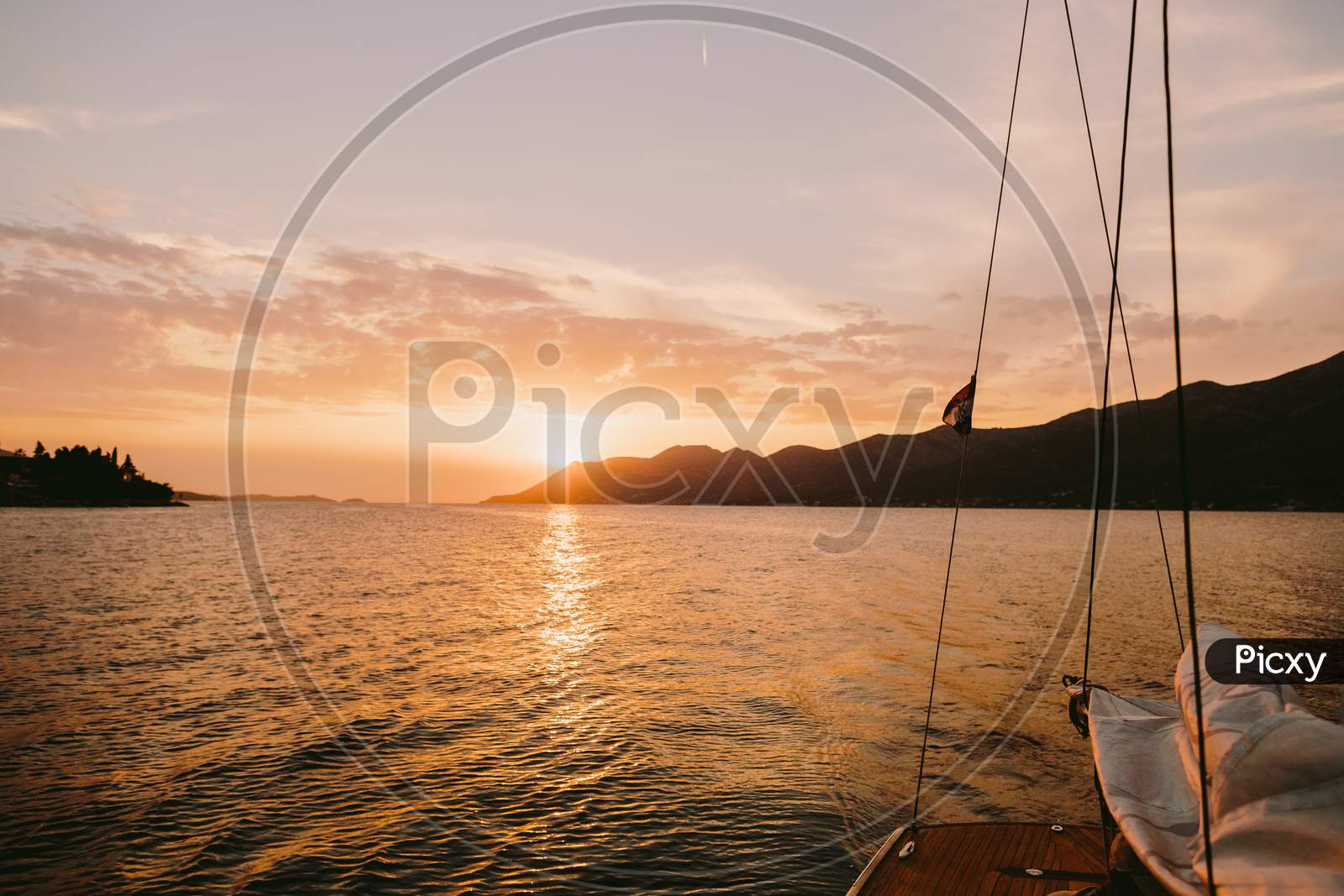 Yacht Sailing At Sunset In Sea With Mountains View