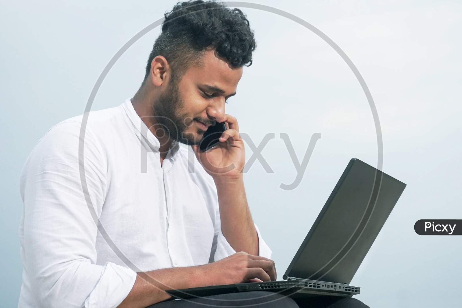 young man using laptop and smart phone together