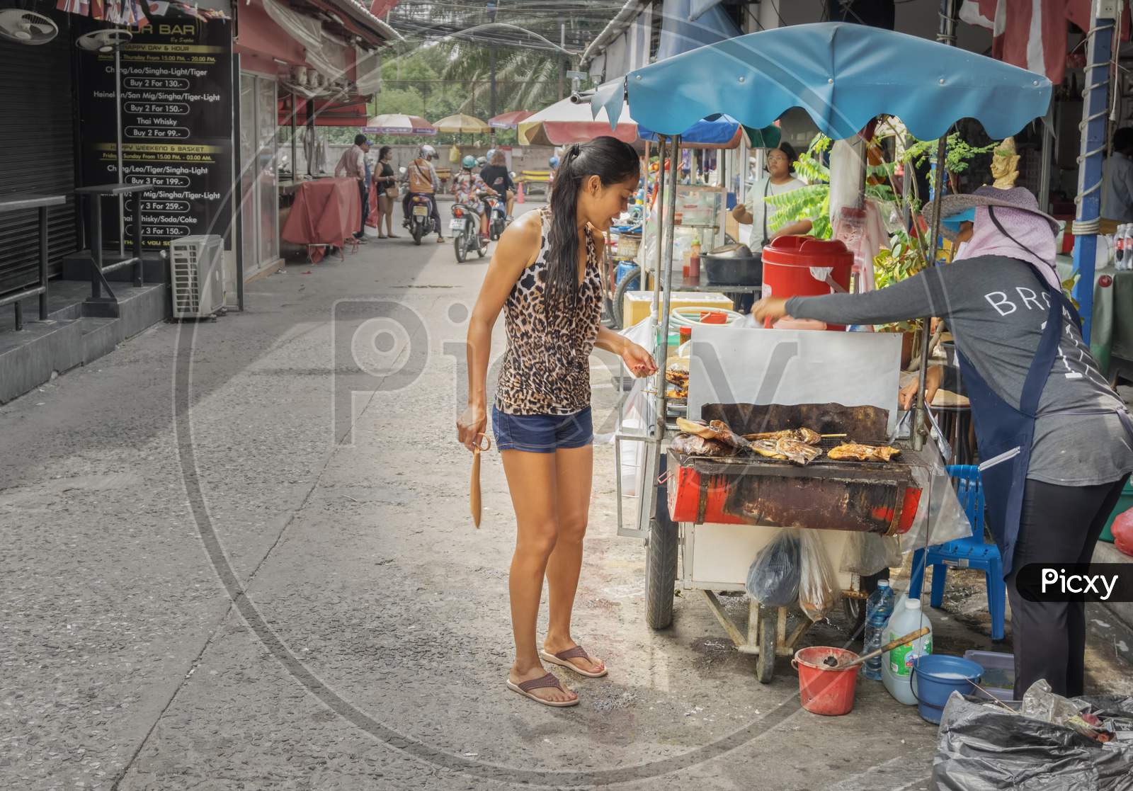 Pattaya,Thailand - April 17,2018: Soi Made In Thailand A Thai Woman Is Buying Some Traditional Food On The Street.