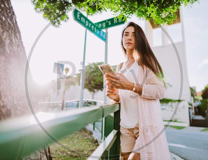 Pensive Woman Using Phone Texting Message Standing On Crossroad