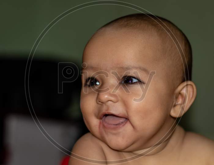 Baby Infant Cute Innocent Smiling Facial Expression With Blurred Background