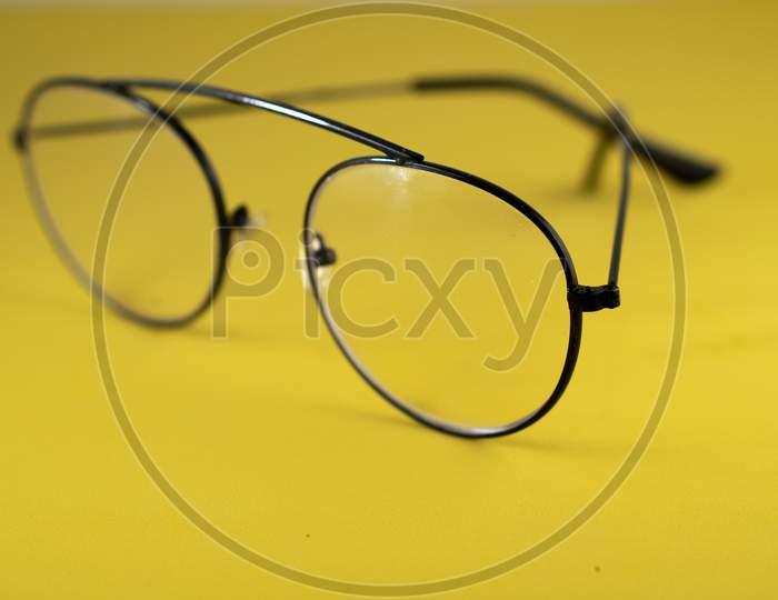 Black frame spectacle (eye glasses) isolated on a yellow background.