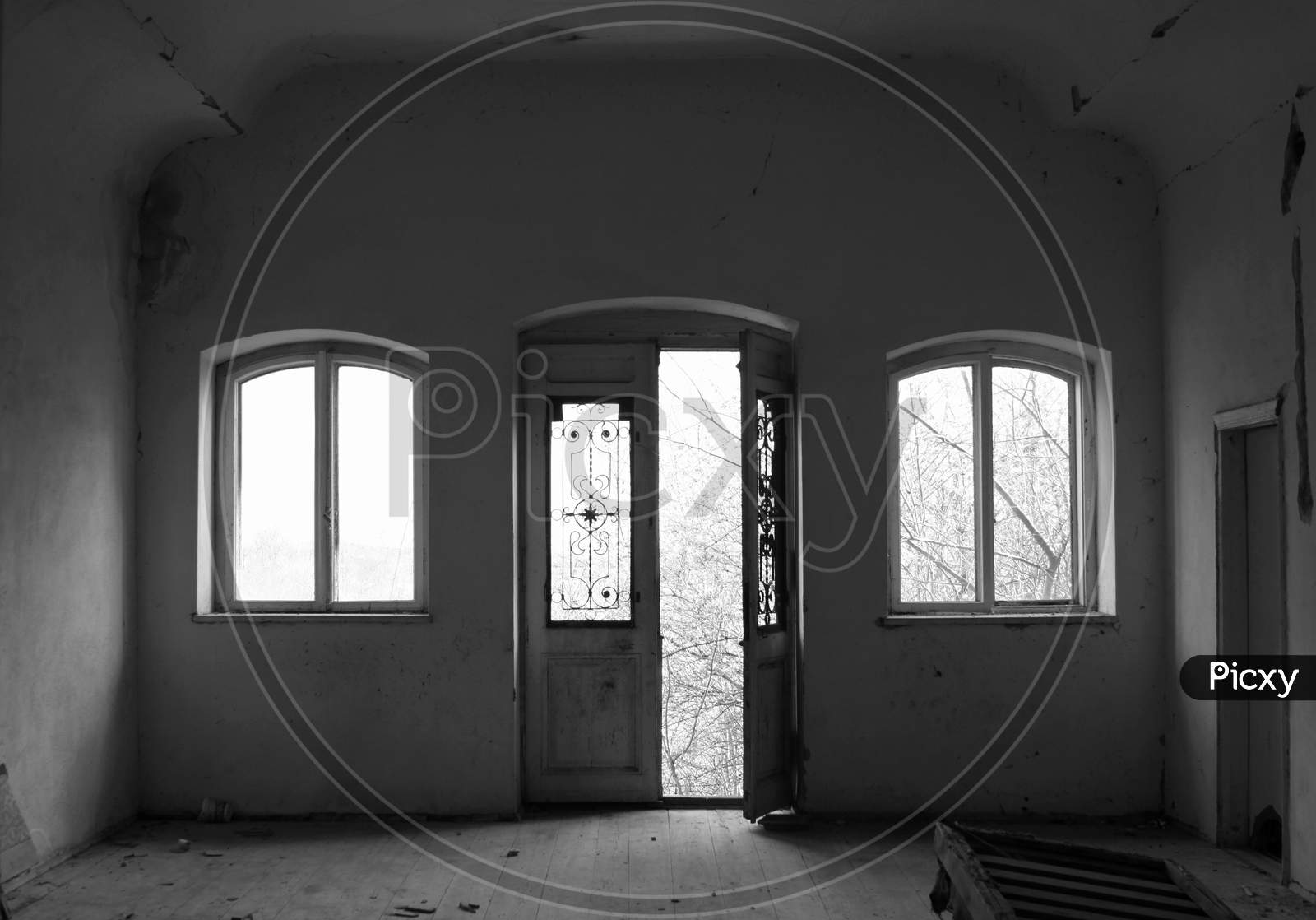 Abandoned Room With Door And Two Windows