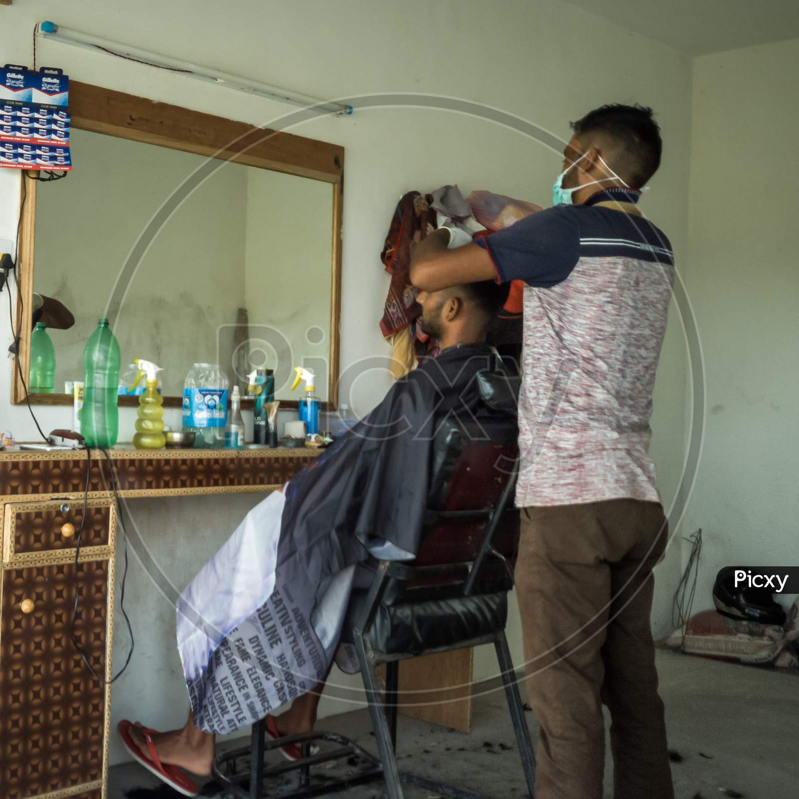 A guy having a haircut in a village in India.