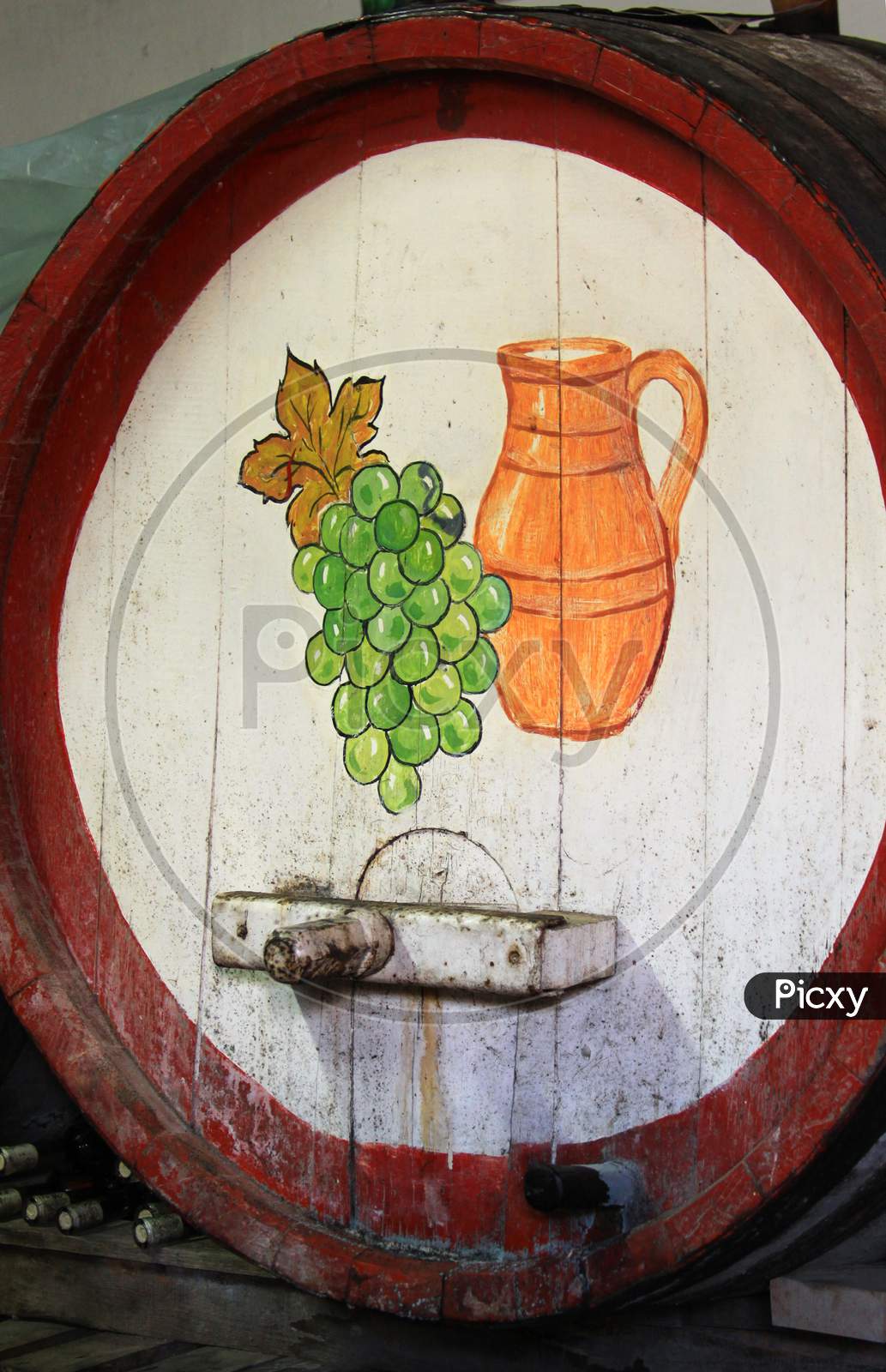 Wine Barrel In Winery With Grapes & Jug In Cellar