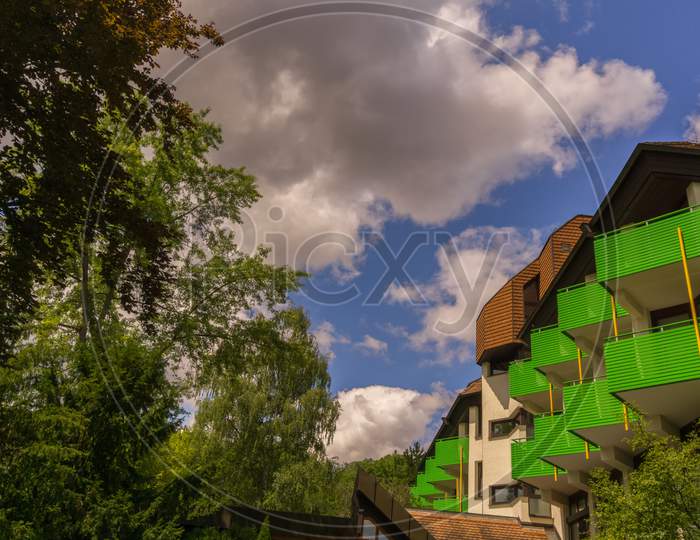 A House With Colorful Balconies Below A Cloudy Summer Sky