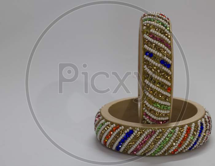 Close Up Of Pair Of Bangles Isolated On White Background With Space For Text