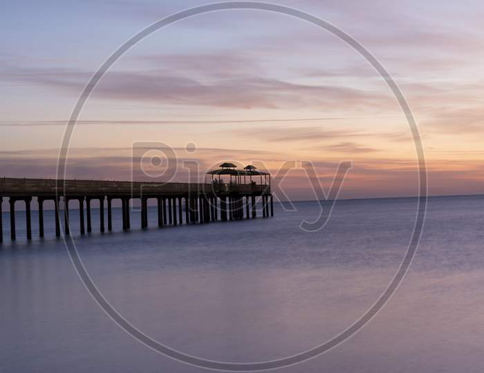 A Long exposure shot of early sunrise with fishing pier