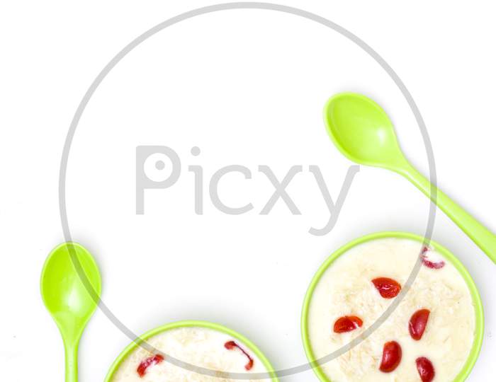 Sewai or kheer consumed on eid or indian festivals. Served with red cherry toppings in a green bowl.