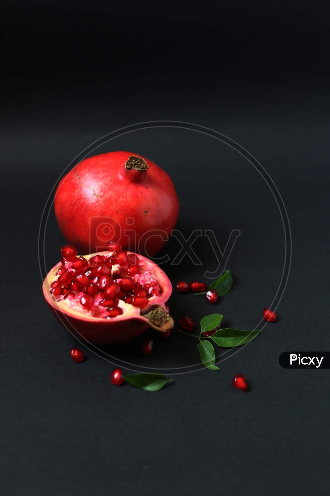 Juicy pomegranate fruit isolated on dark background