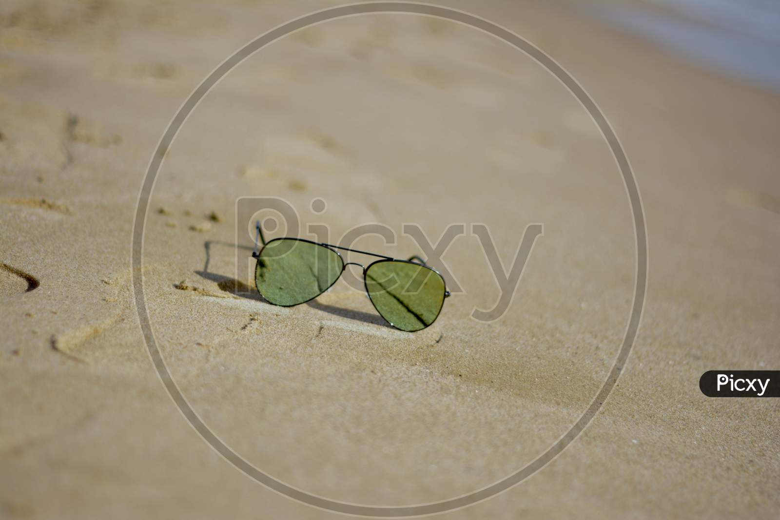 picture of sunglasses  on a sand beach