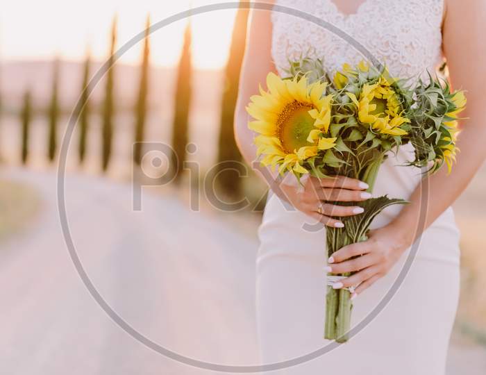 Sunflowers Bouquet Holding By Bride In Tuscany At Sunset