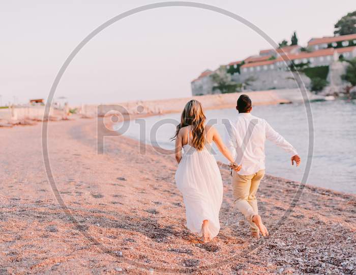 Couple Run Beach At Sunset