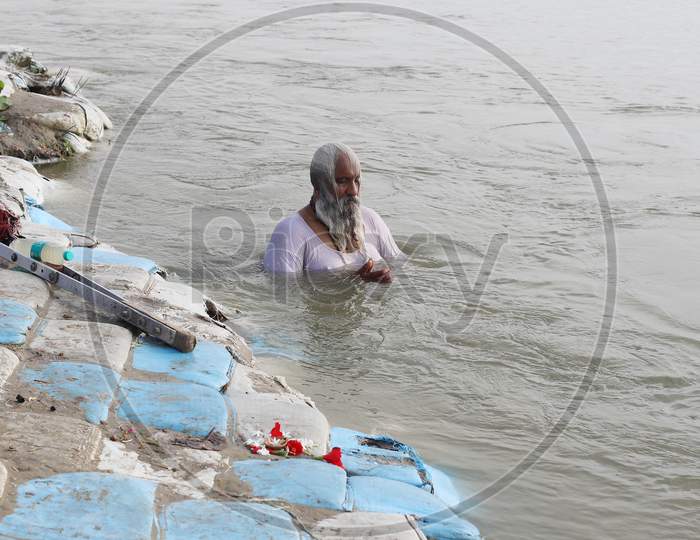 A Sadhu Or Holy Man Offering Prayers After Takes Holy Dip In The Sangam, Confluence Of Three Rivers, The Ganga, The Yamuna And Mythical Saraswati After Lunar Eclipse Or Chandra Grahan In Prayagraj, June 6, 2020.