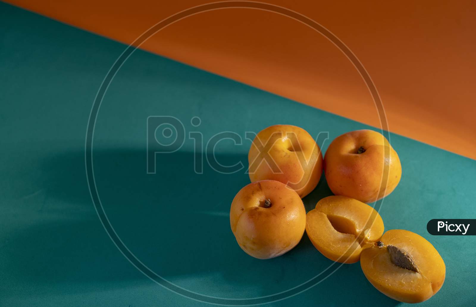 Juicy peach on a orange and green background.