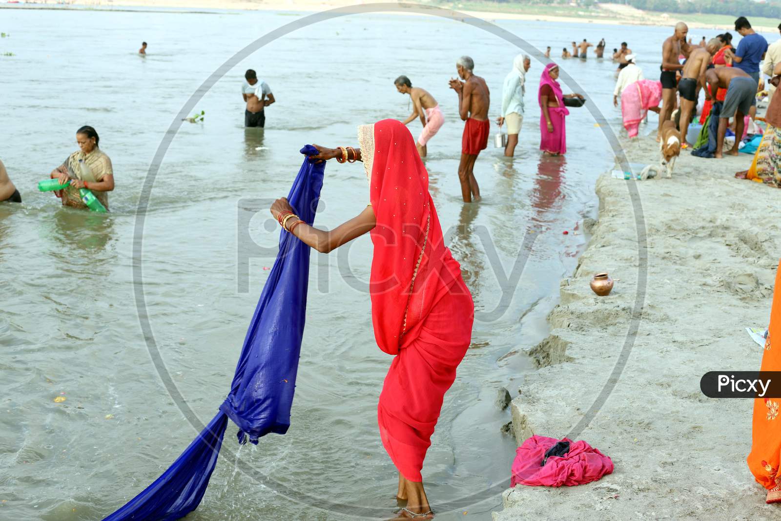 A Woman Wash Her Cloths In The Ganga River After Takes Holy Dip In The Sangam, Confluence Of Three Rivers, The Ganga, The Yamuna And Mythical Saraswati After Lunar Eclipse Or Chandra Grahan In Prayagraj, June 6, 2020.