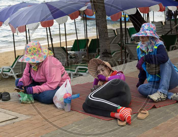 Pattaya,Thailand - October 23,2018:Beach Road Three Female Thai Workers Relax Near The Beach.