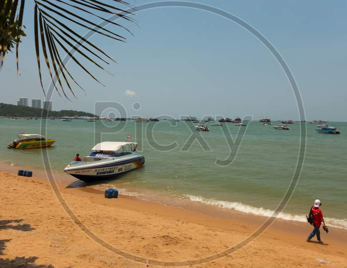 Pattaya,Thailand - April 12,2018: The Beach Tourists Relax And Swim There And Rent Boats For Trips.Some Thai People Sell Souvenirs,Food And Drinks To Them.