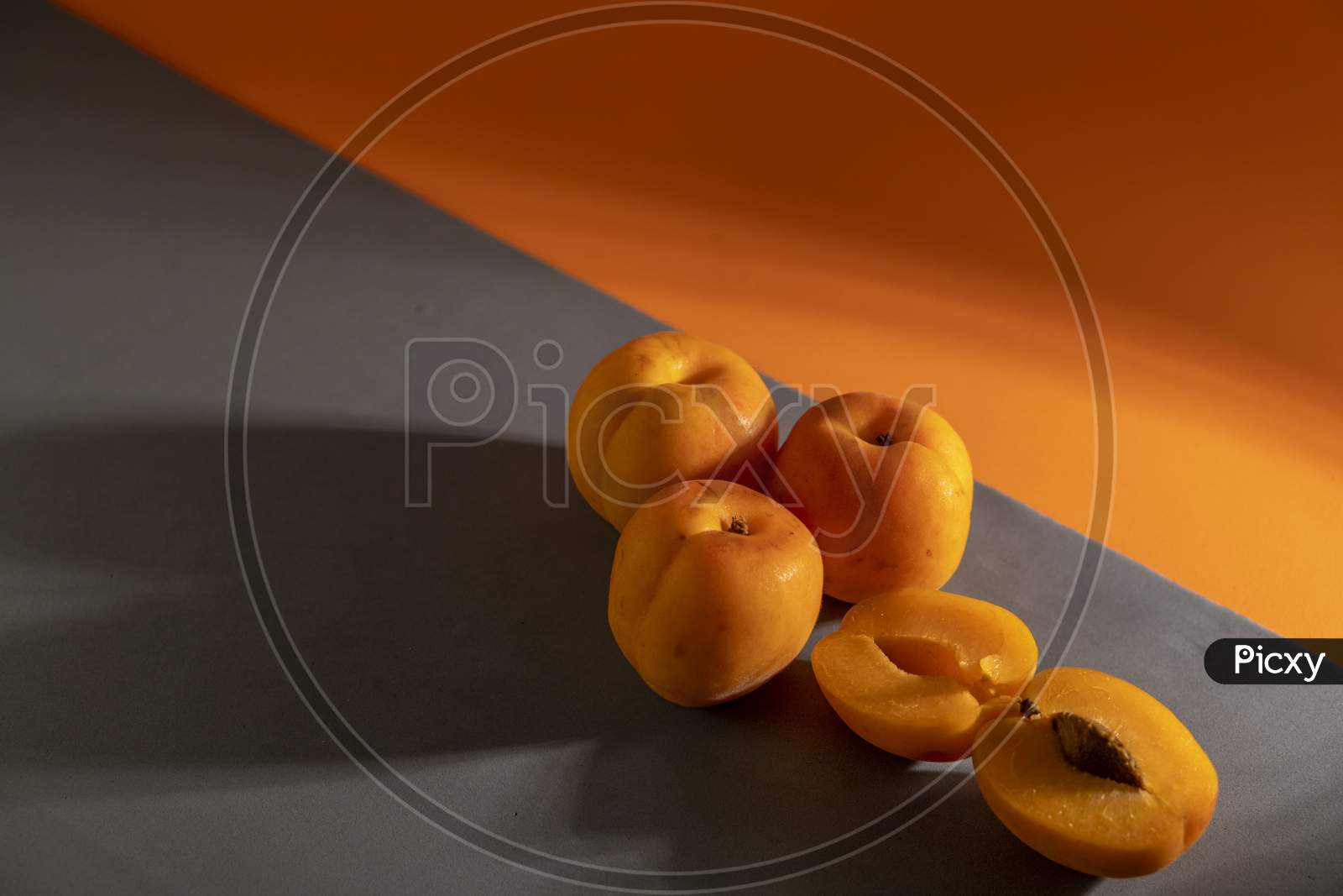 Juicy peach on a orange and grey background.