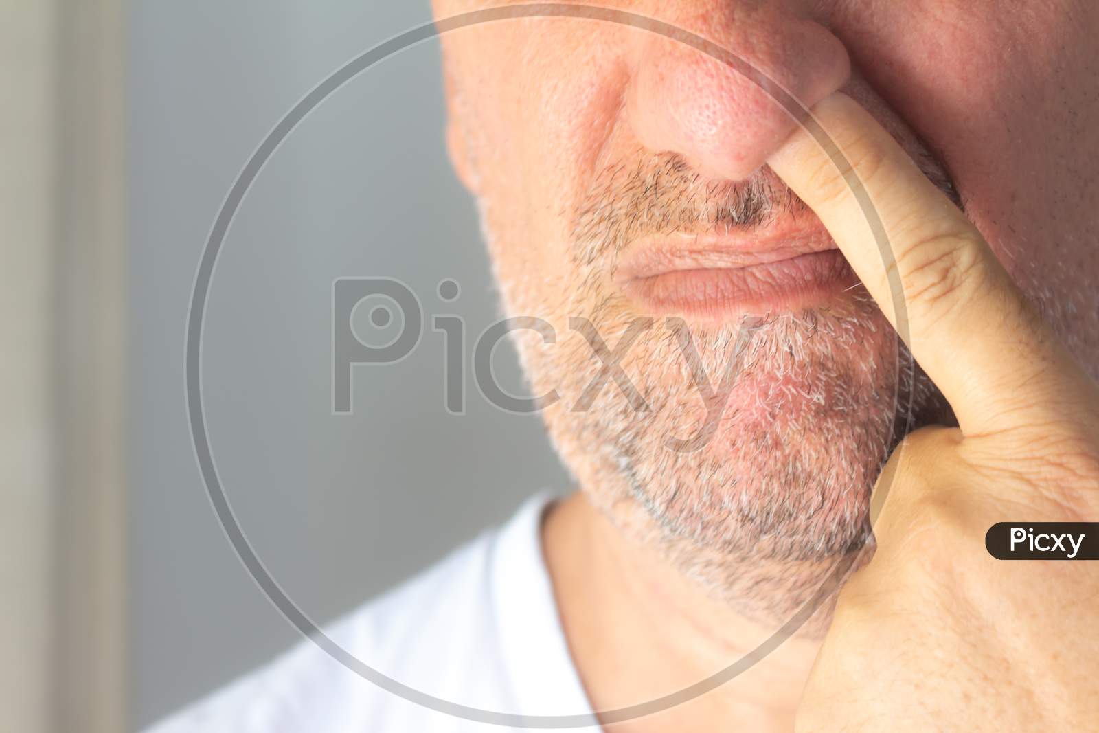 Caucasian Middle-Aged Man With Slightly Grown Beard. Man With His Finger Up His Nose.