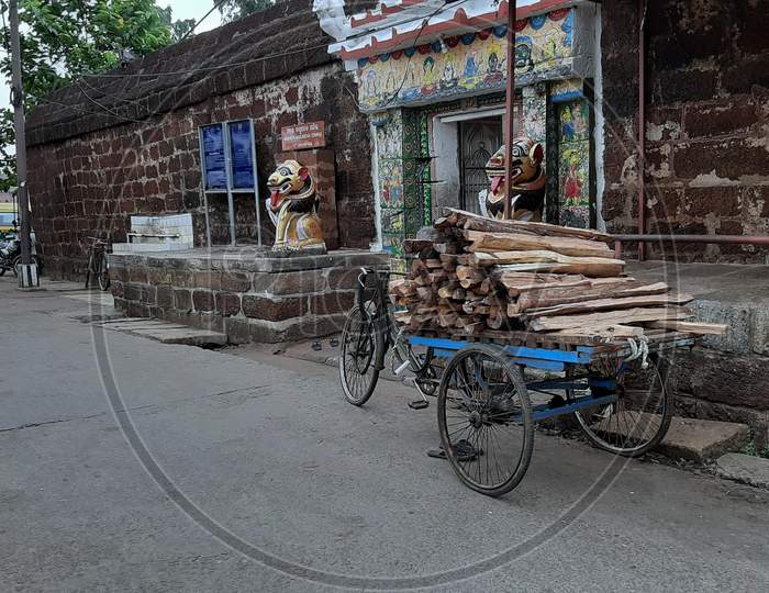 A trolley stand outside of Temple Ananta Basudev with wood to supply for cooking of prasad