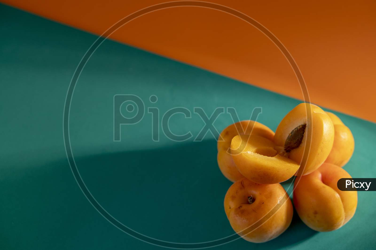 Juicy peach on a orange and green background.