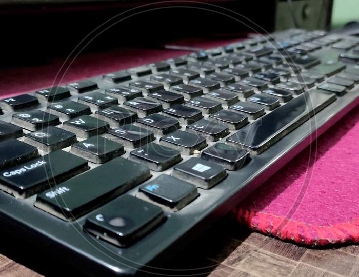 Shot Of A Dirty , Black Computer Keyboard With A Computer Mouse