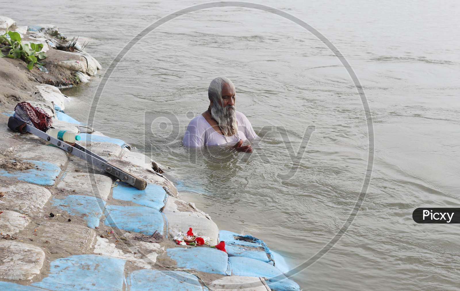 A Sadhu Or Holy Man Offering Prayers After Takes Holy Dip In The Sangam, Confluence Of Three Rivers, The Ganga, The Yamuna And Mythical Saraswati After Lunar Eclipse Or Chandra Grahan In Prayagraj, June 6, 2020.