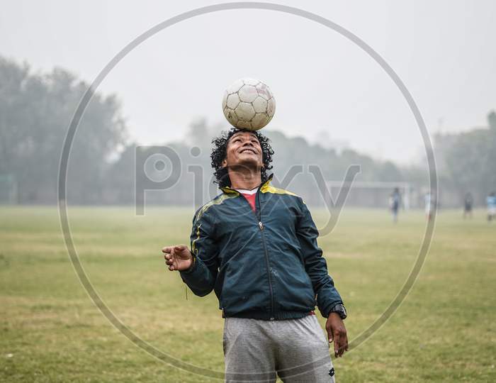 New Delhi, Delhi / India- June 6 2020 : An Mid Aged Football Player Doing Head Stall In A Green Field.