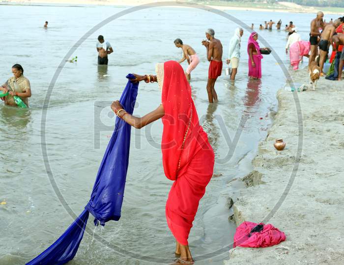 A Woman Wash Her Cloths In The Ganga River After Takes Holy Dip In The Sangam, Confluence Of Three Rivers, The Ganga, The Yamuna And Mythical Saraswati After Lunar Eclipse Or Chandra Grahan In Prayagraj, June 6, 2020.