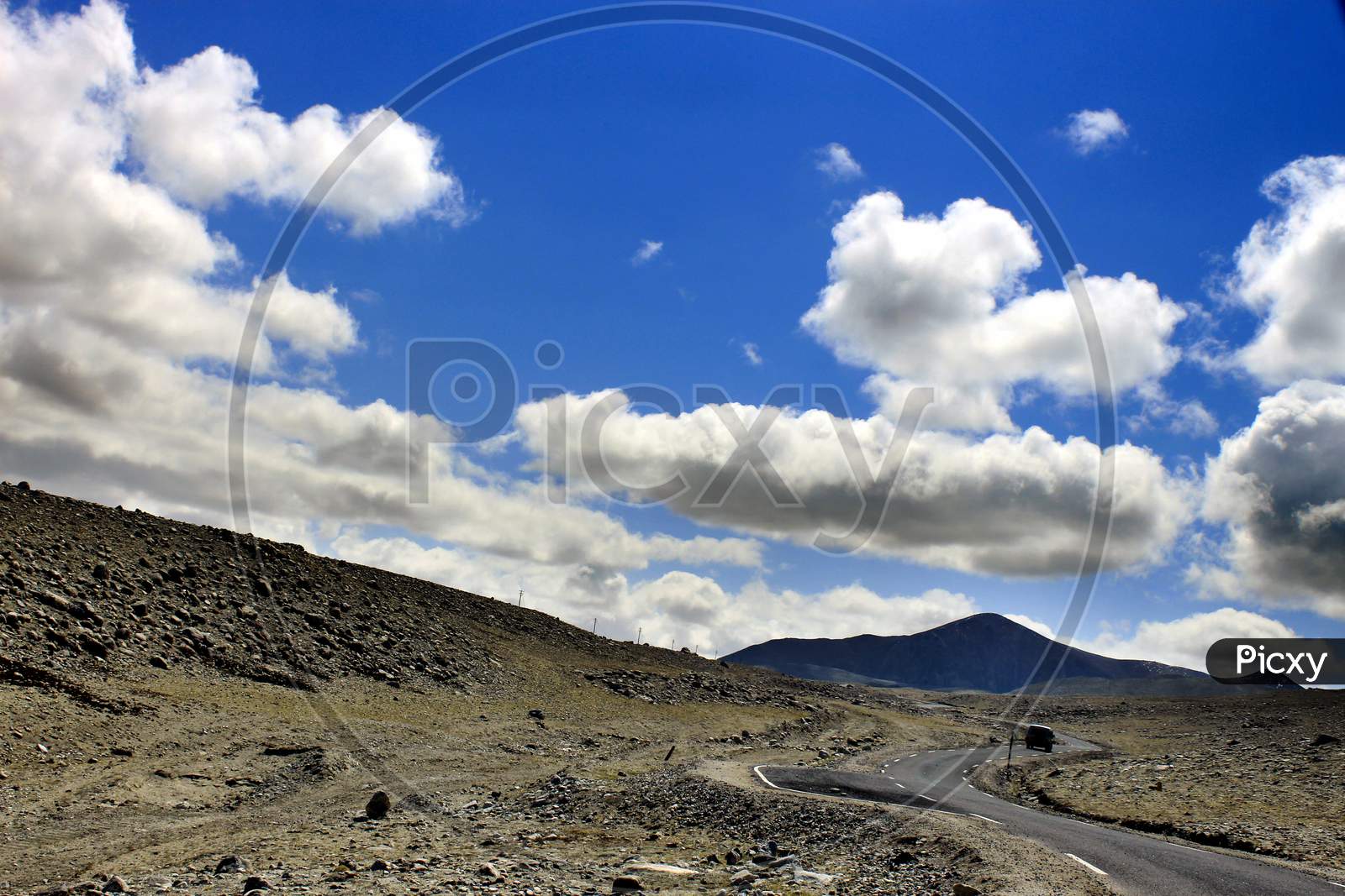 A Single Lane Road in Sikkim with Mountains and Huge Clouds