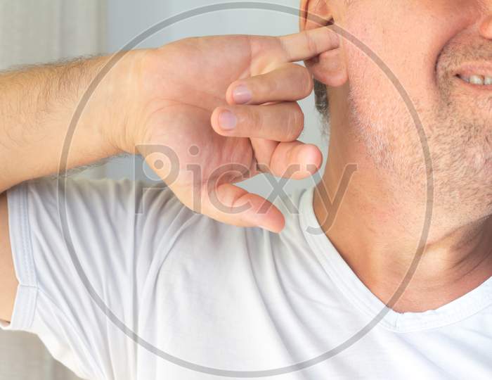 Caucasian Middle-Aged Man. Latino Man With Finger In Ear.