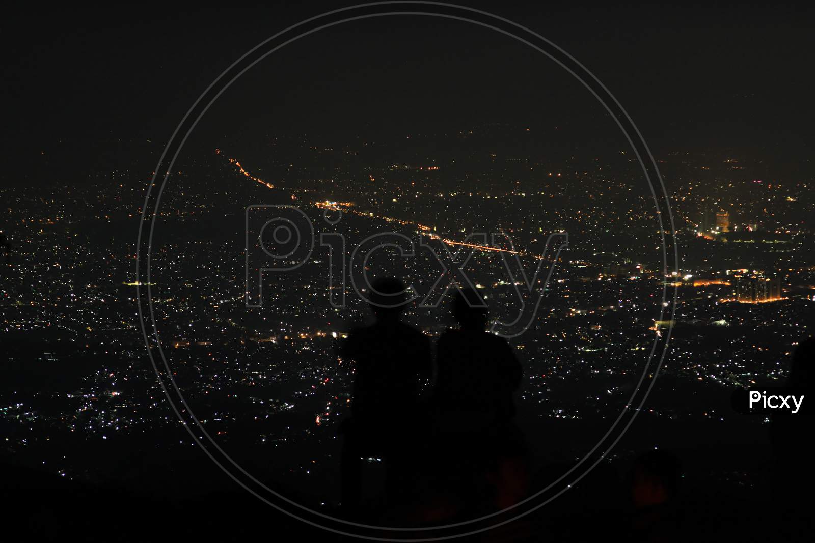 Couple Silhouette Above The City Lights At Night