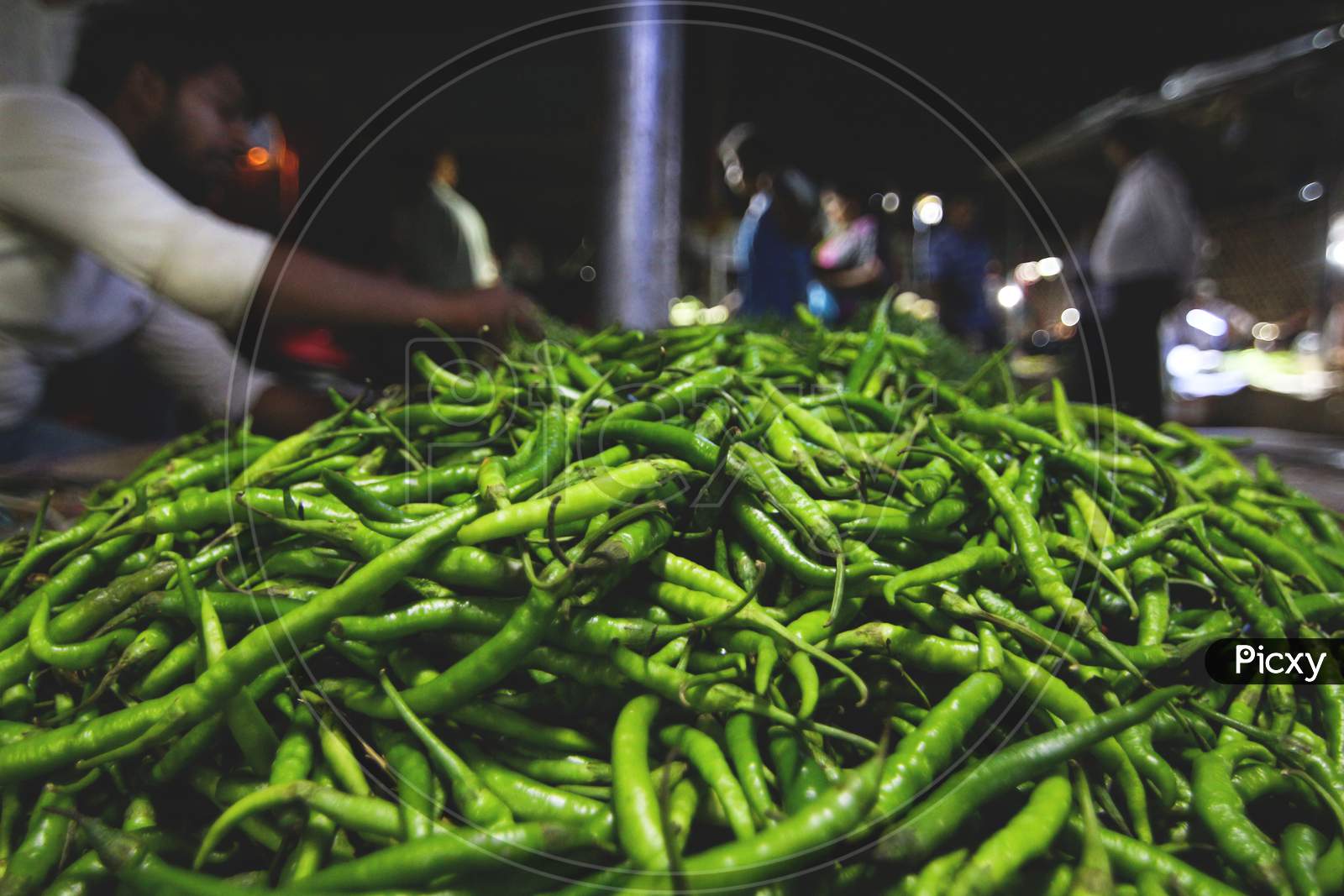 A Heap Of Green Chillies Kept By A Greengrocer In An Indian Vegetable Market.