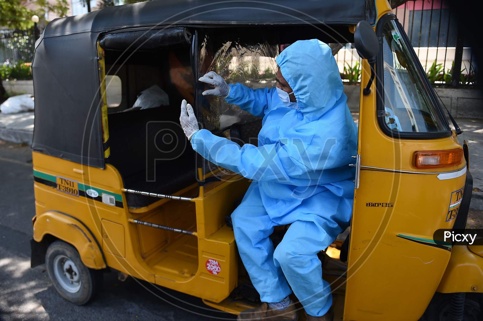 A Driver Wearing Personal Protective Equipment (Ppe) Disinfects His Auto Rickshaw in Chennai, Tamil Nadu
