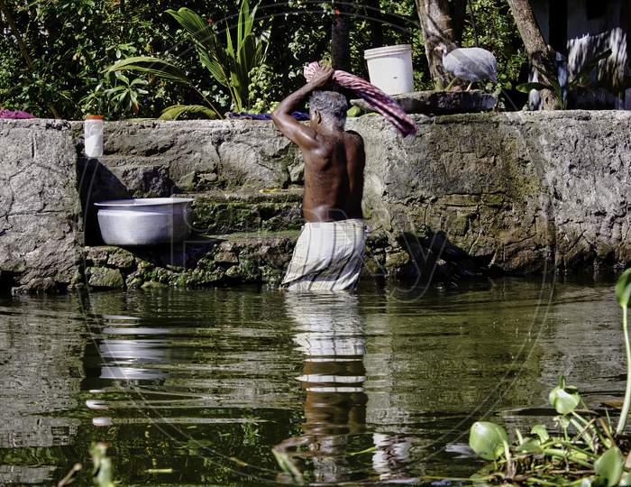 A Man Washing His Cloths In An Traditional Way In A Small Village In Alleppey Located In Souther State Kerala