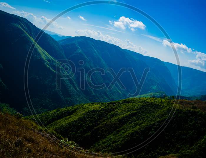 Natural view of the folded mountains and lush green valleys with clear sky and clouds of Cherrapunji, Meghalaya, North East India