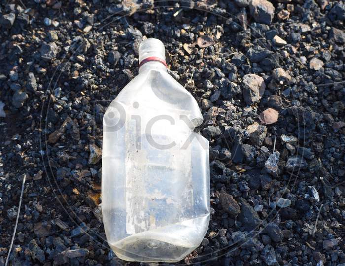 a plastic bottle is thrown by someone on a roadside