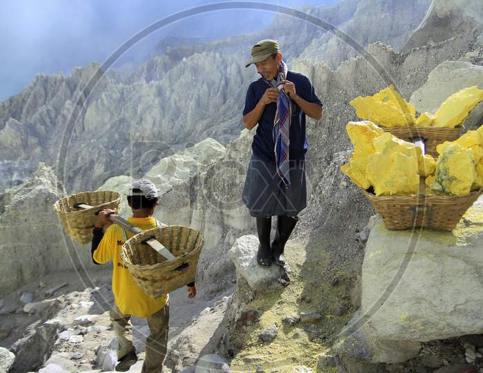 Sulfur Miners take a short break when carrying sulfur