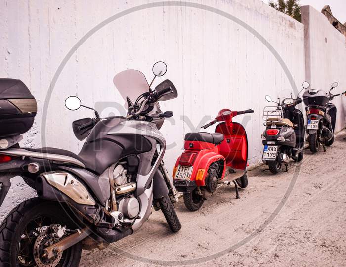 Santorini / Greece - April 25, 2019: Two wheelers parked near wall in the city