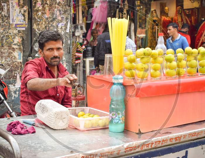 Delhi / India - May 12, 2019 : Refreshing  Lemon water seller with his stall in Market waiting for customer. This is most preferred drink by Indians during Summer to protect themselves from heat