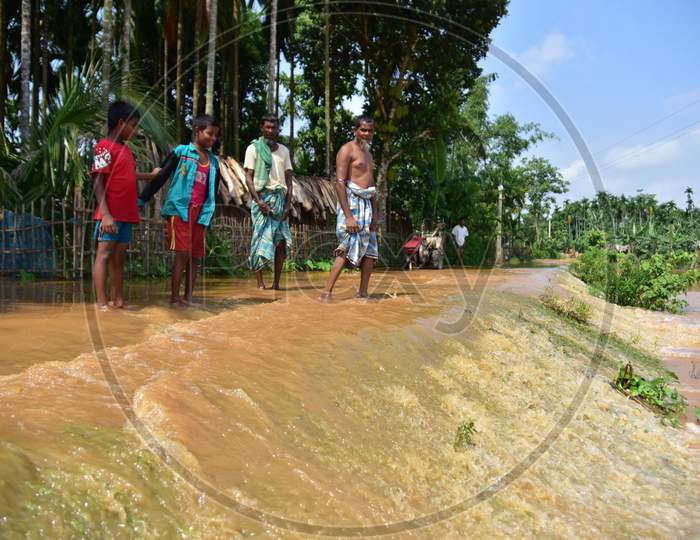Villagers  Wade Through A Flooded Road At  Pramila Village Near Kampur In Nagaon District Of Assam On June 7,2020