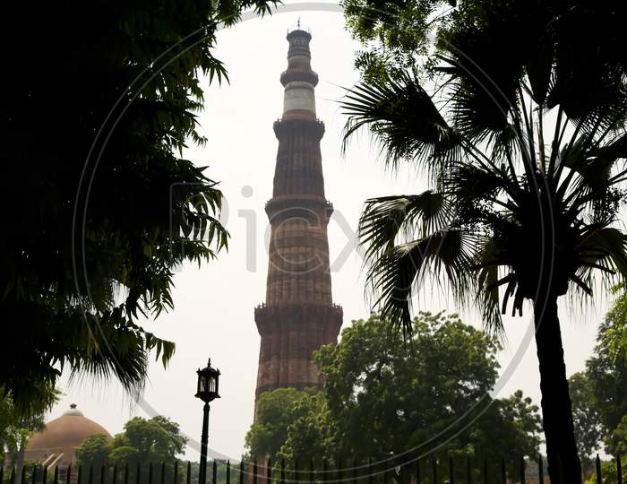 A View Of The Minar Through The Trees, The Combination Of Man Made And Natural Makes A Beautiful Place In India