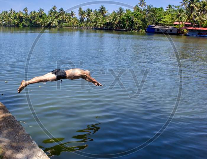 A Man Dive In The Backwater Of Allepey