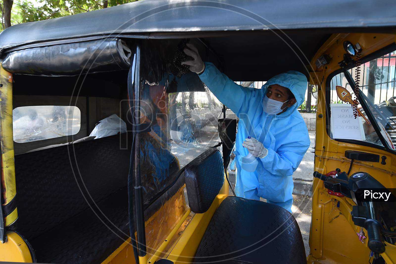 A Driver Wearing Personal Protective Equipment (Ppe) Disinfects His Auto Rickshaw in Chennai, Tamil Nadu