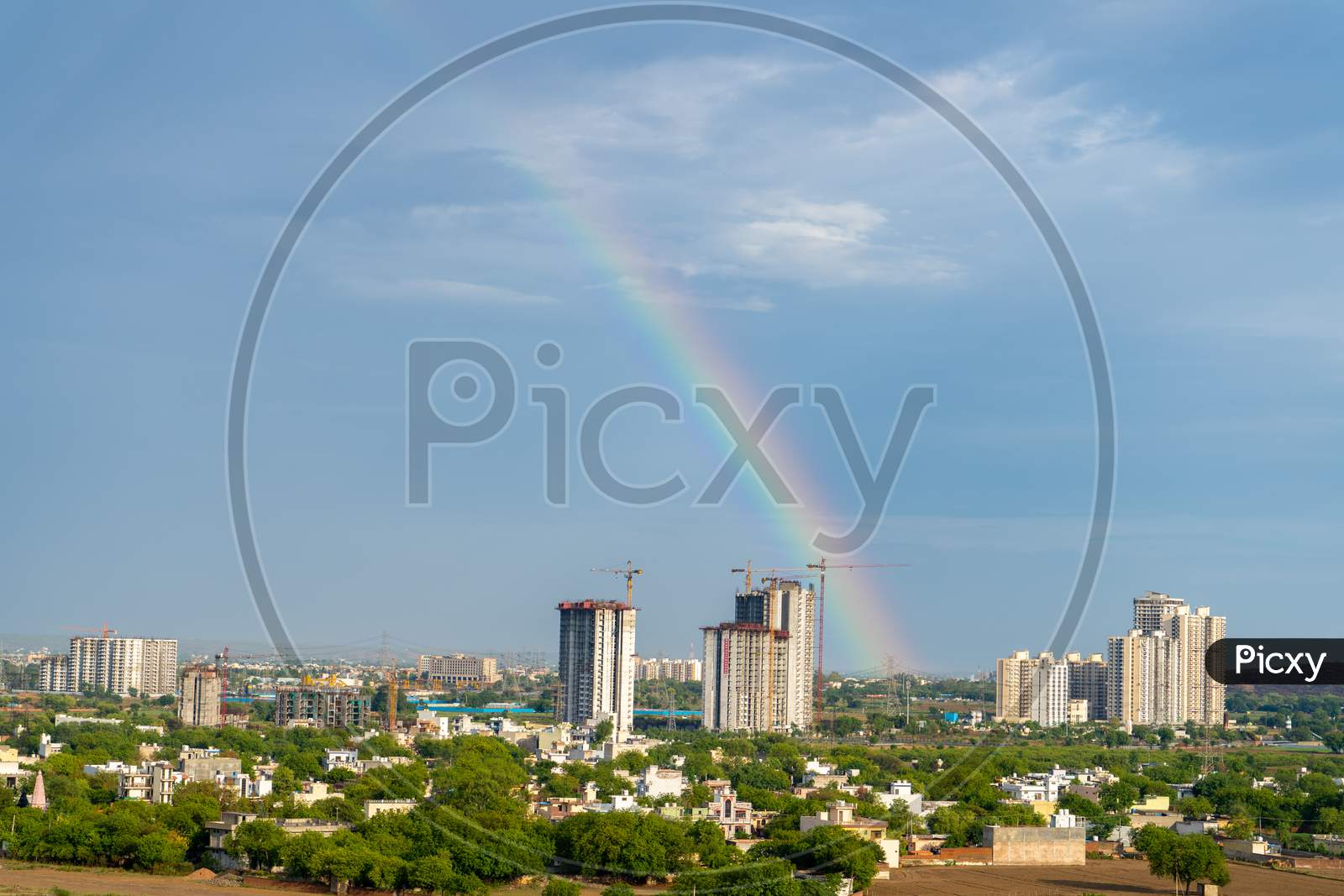 Aerial Cityscape Shot Of Buildings In Gurgaon Delhi Noida With A Rainbow Behind Them On A Monsoon Day