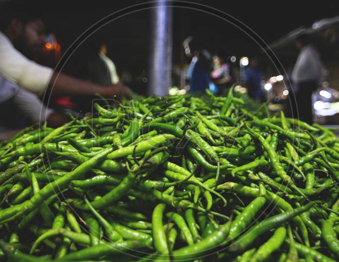 A Heap Of Green Chillies Kept By A Greengrocer In An Indian Vegetable Market.